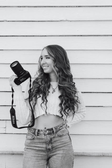 Bri Heard, photographer, holding a Nikon camera